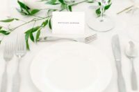 32 a minimalist and airy tablescape in white, with candles and a touch of fresh greenery is a very fresh and cool idea