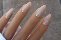 32 blush almond nails with gold metallic touches are an ultra-modern and chic nail art for a modenr or minimalist bride