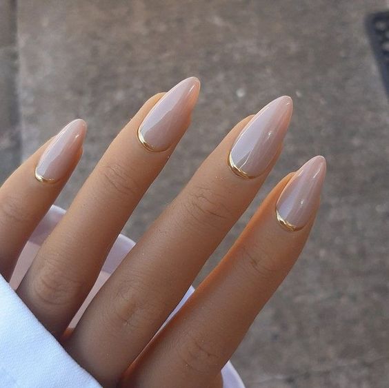 blush almond nails with gold metallic touches are an ultra modern and chic nail art for a modenr or minimalist bride