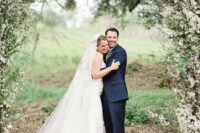 33 a romantic spring garden wedding arch covered with greenery and blooming branches looks fabulous and screams blooming and love