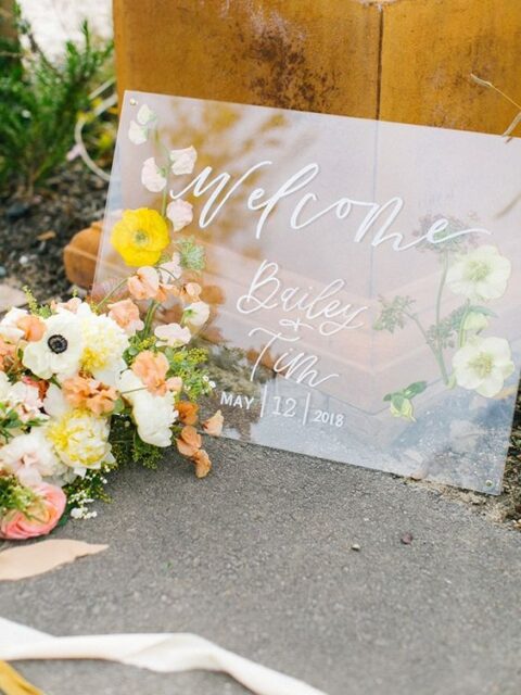 a wedding welcome sign with pressed flowers and white calligraphy is amazing for a spring wedding