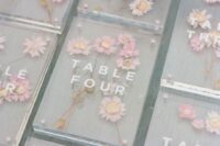 beautiful table numbers with pressed pink flowers inside are gorgeous for delicate wedding table looks