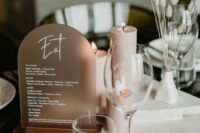 36 a minimalist winter wedding table with a copper arched menu, dried grasses, white stone pieces stacked and blush candles