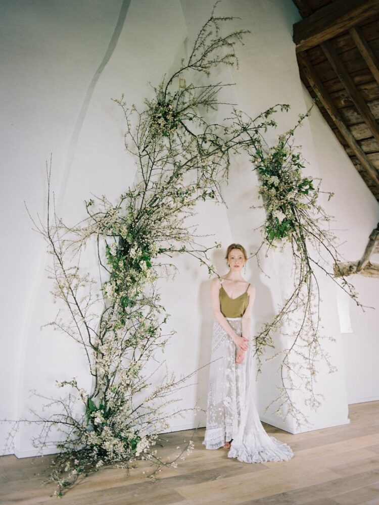 a wedding altar taking inspiration from living walls - uniquely shaped twigs were placed directly on the wall to form an altar area
