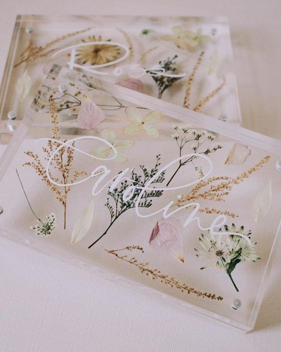 clear acrylic wedding invitations with blooms and leaves, with white calligraphy are amazing for a wedding in spring or summer
