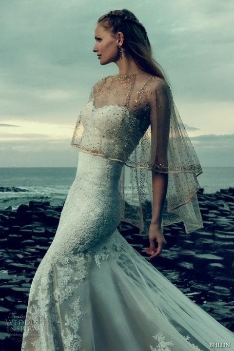 a sheer high low capelet with gold beading is a glam and chic solution for a bride getting married in a cold season