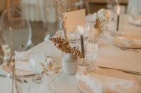38 a natural and minimalist wedding table setting with all neutral everything, dried blooms, berries and grey candles is a stylish idea