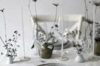 40 a neutral minimalist wedding tablescape with grey plates, white vases with dried blooms, simple cutlery and thin and tall candles