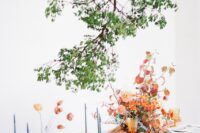 41 a creatively suspended greenery branch over the table elevates the whole tablescape and adds freshness to the orange and rust table decor