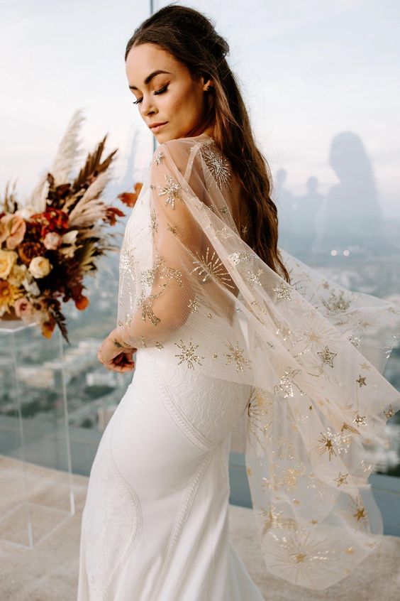 a sophisticated clear bridal capelet with celestial gold embroidery is a beautiful accessory to rock, it looks amazing