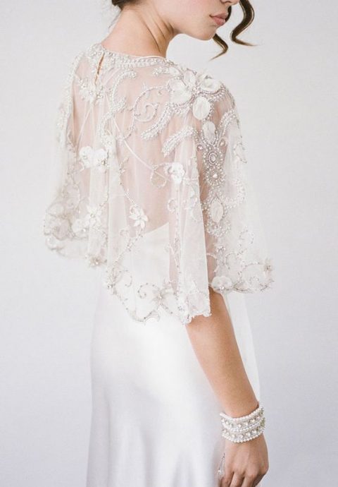 an exquisite sheer wedding capelet with white floral applique and silver embroidery and embellishments is wow