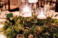 50 a beautiful woodland wedding centerpiece of evergreens and berries and tall glasses with floating candles is cool
