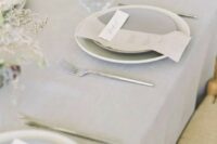 50 an airy minimalist wedding tablescape with a grey tablecloth, plates and napkins, dried blooms and candles is a stylish idea