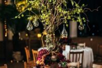 53 a whimsical enchanted forest wedding centerpiece of a vine tree with greenery, drops with candles, bold blooms at the base of the tree