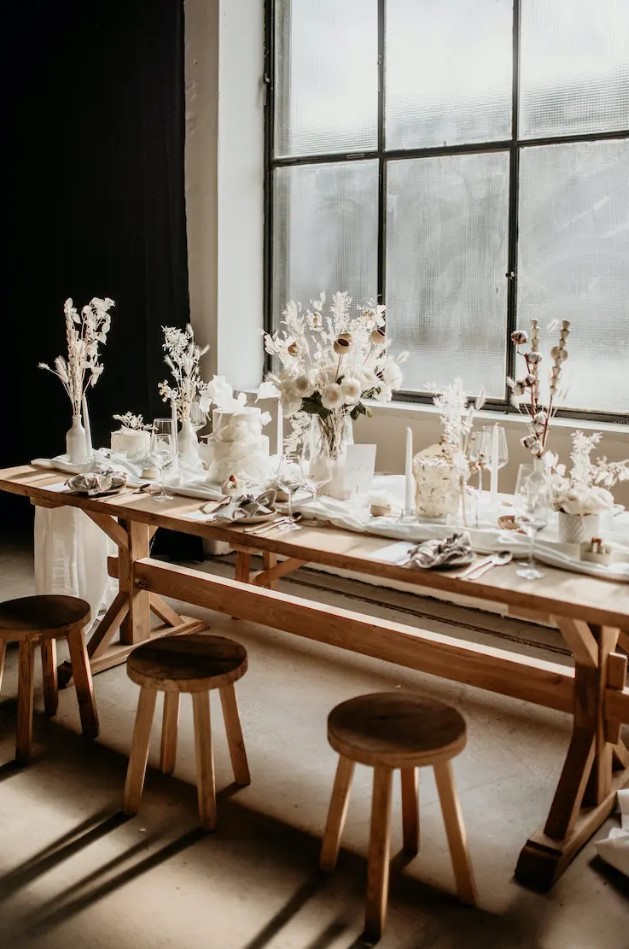 an organic winter wedding tablescape with white blooms, dried flowers and grasses, cotton buds and all white everything