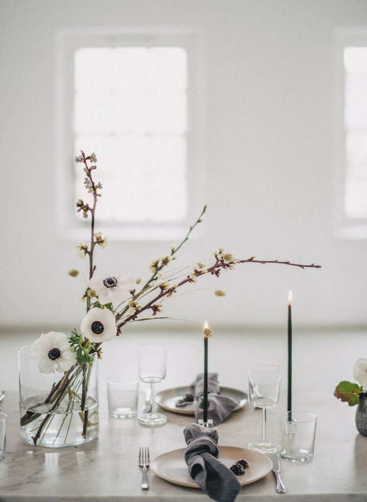 a stylish minimalist wedding centerpiece composed of blooming branches and white anemones is a lovely idea for a neutral wedding