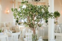 56 a stylish wedding centerpiece of greenery branches and with foliage inside the vase is a very pretty and natural idea