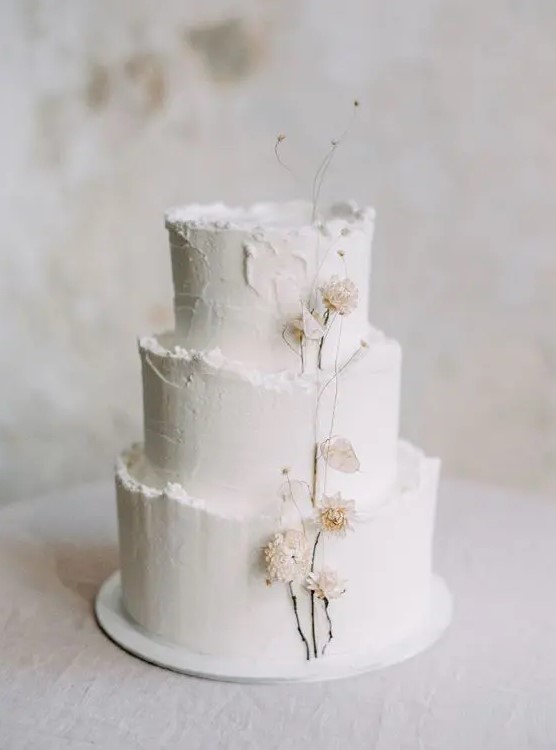 a textural white winter wedding cake with a raw edge and dried blooms is a lovely and cool idea that you may rock