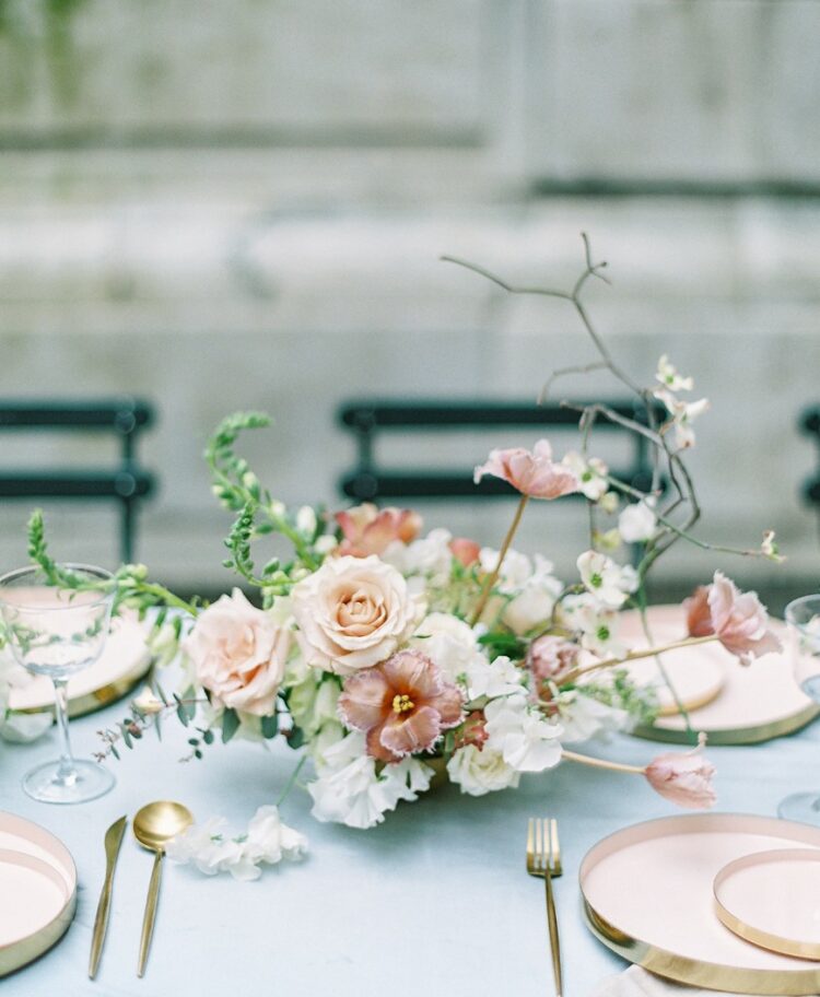 a sophisticated wedding centerpiece cohesively incorporates twigs into a lush, bloom-focused arrangement for a unique look