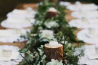 58 a simple woodland wedding tablescape with a runner made of moss, greenery, succulents and tree branches with candles