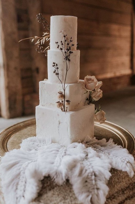 a delicate four tier wedding cake with square and round tiers, sugar patterns, dried blooms and herbs is a stunning idea