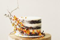 66 a naked one-tier wedding cake with an over-the-top presence thanks to twig and berry accents