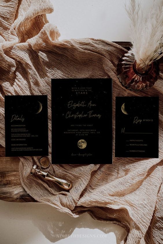 a black celestial wedding invitation suite with gold calligraphy and moon phases is a chic and stylish idea for a wedding