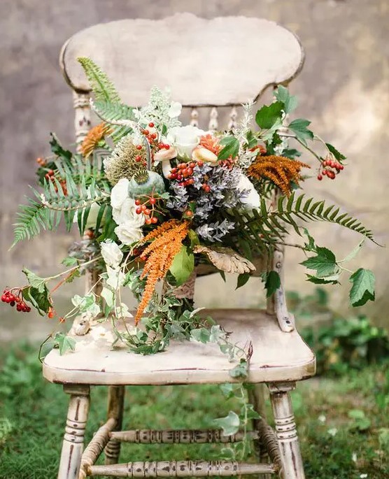 a bold woodland boho wedding bouquet with white roses, berries, leaves, colorful foliage and cascading touches
