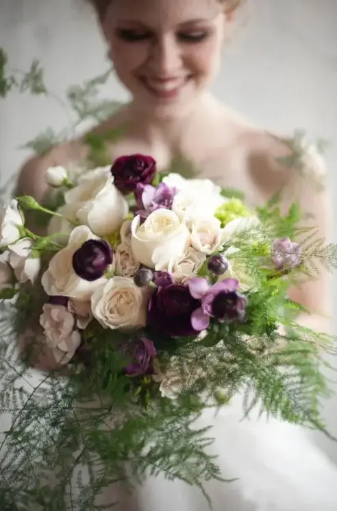 a bright wedding bouquet with purple and white blooms, with ferns is a beautiful option for a dramatic woodland bride