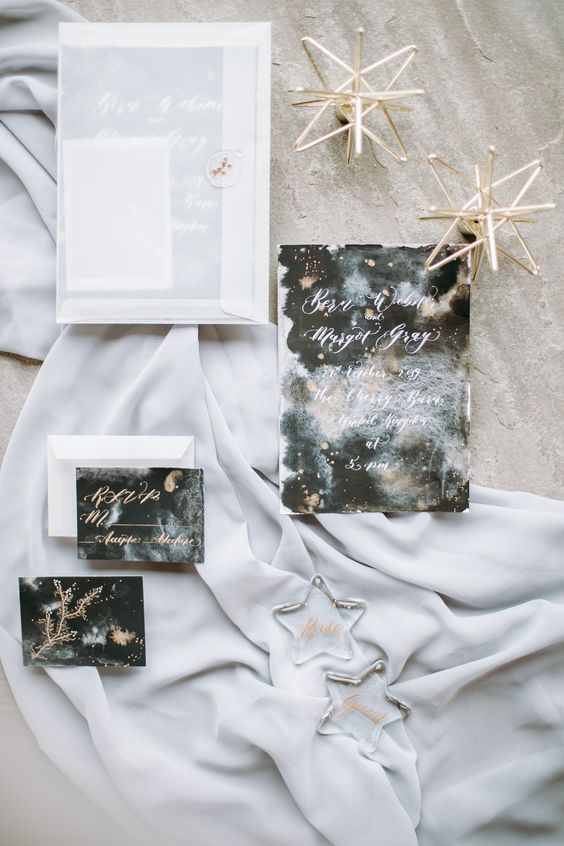 a dreamy celestial wedding invitation suite with a white envelope. black, grey and white cards and gold and white calligraphy is wow
