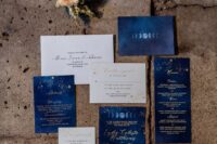 a fab bold blue and white wedding invitation suite with gold calligraphy and constellations is a dreamy idea for a wedding