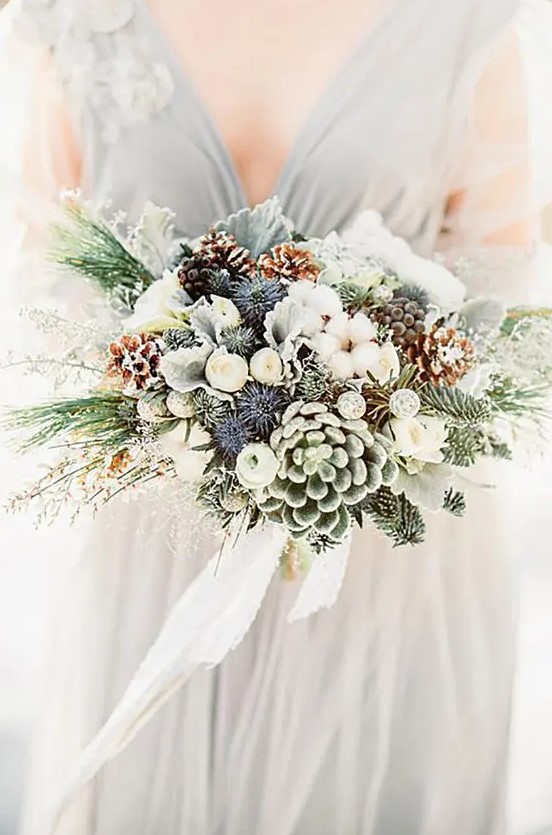 a gorgeous bouquet with snowy pinecones, thistles, succulents, evergreens and white cotton