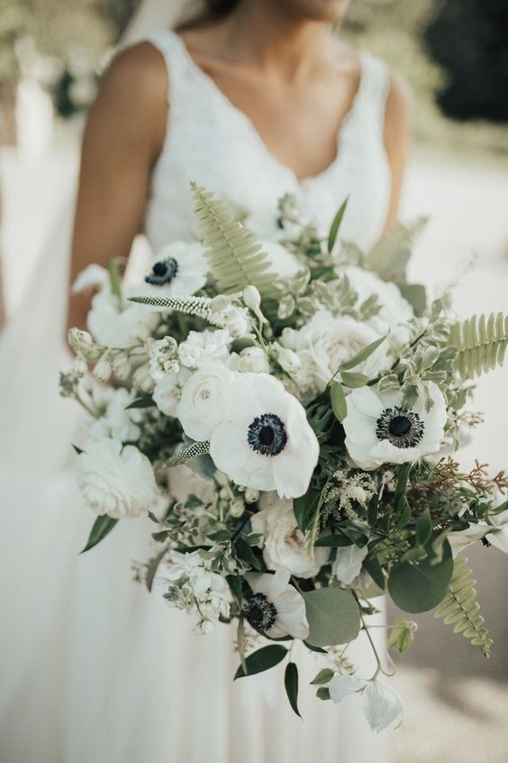 a gorgeous wedding bouquet of white ranunculus, anemones, astilbe and eucalyptus and fern is amazing