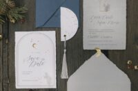 a grey, white and navy wedding invitation suite with calligraphy, gold half moons and a grey tassel is a lovely idea for a celestial wedding