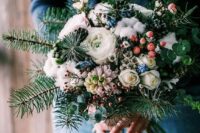 a lovely winter wedding bouquet of evergreens, white blooms, berries, blue touches, eucalyptus and cotton is amazing