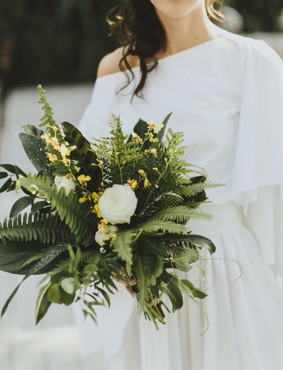 a modern wedding bouquet of fern, white ranunculus, small yellow bloom fillers is a catchy idea
