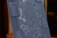 a navy constellation wedding seating chart with tables and constellations is a cool idea for a celestial wedding