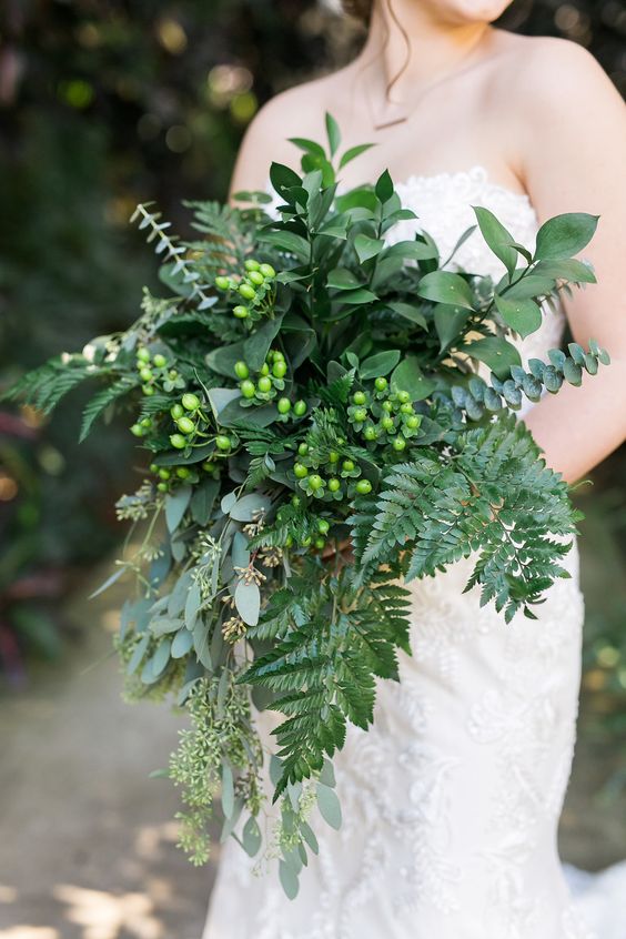 a stylish and lush fern wedding bouquet with foliage, berries and seeded eucalyptus is great for a woodland bride