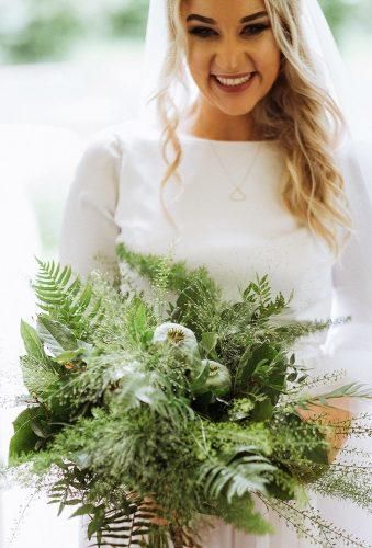 a super lush wedding bouquet of evergreens and foliage, seed pods and twigs of various kinds is amazing