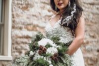 a super lush wedding bouquet of evergreens, white blooms, pinecones is a lovely idea for a wedding
