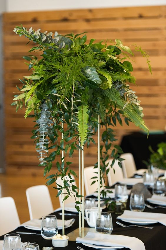 a tall wedding centerpiece of eucalyptus, fern and other greenery is a stylish modern solution for a wedding
