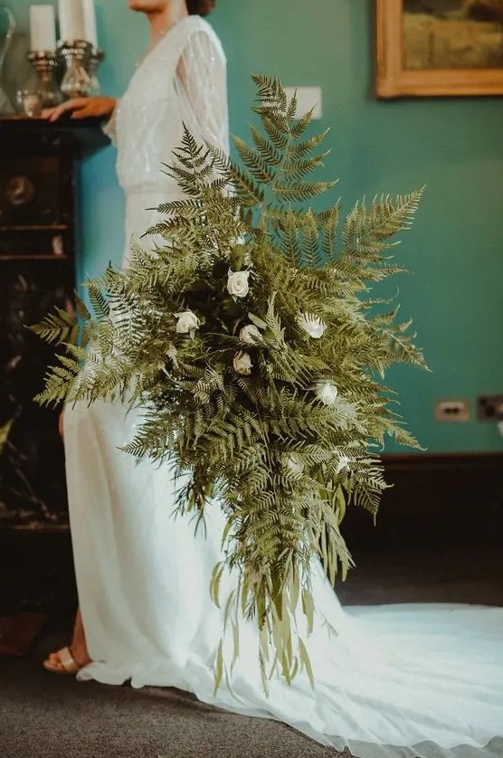 an oversized fern and white rose wedding bouquet with plenty of texture and dimension is a pretty idea for a woodland wedding