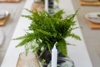 simple fern centerpieces, candles, colored glass and potted foliage for a woodland-inspired wedding tablescape