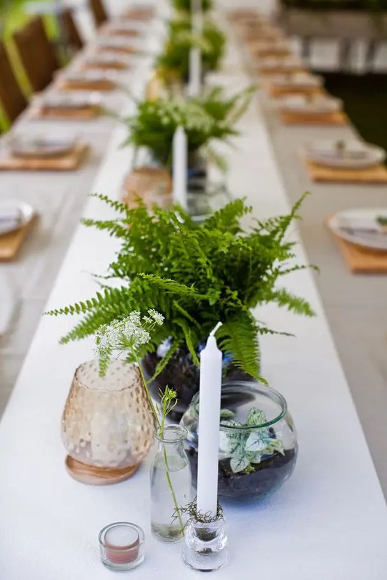 simple fern centerpieces, candles, colored glass and potted foliage for a woodland-inspired wedding tablescape