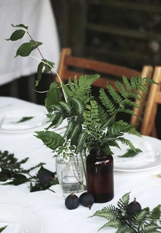 some ferns in vintage apothecary bottles are great for a woodland wedding, add figs for more interest