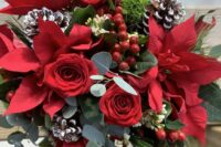 02 a winter wedding bouquet with red roses and poinsettias, snowy pinecones, berries and greenery is a bold and cool idea