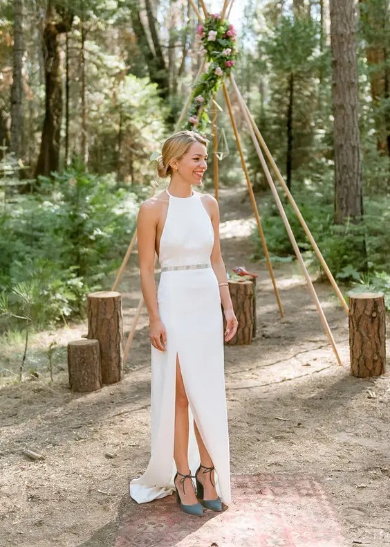 a minimalist halter neckline wedding dress with an embellished belt and dark green suede shoes for a woodland wedding