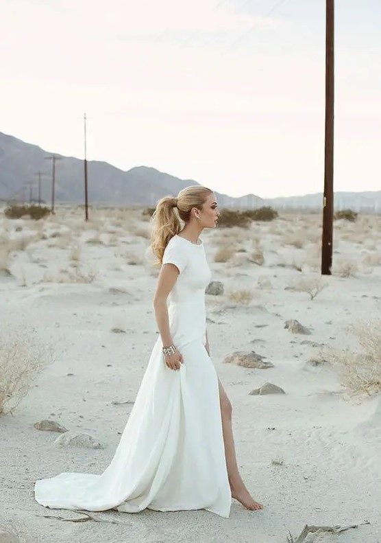 a minimalist short sleeve wedding dress with a front slit and a high neckline