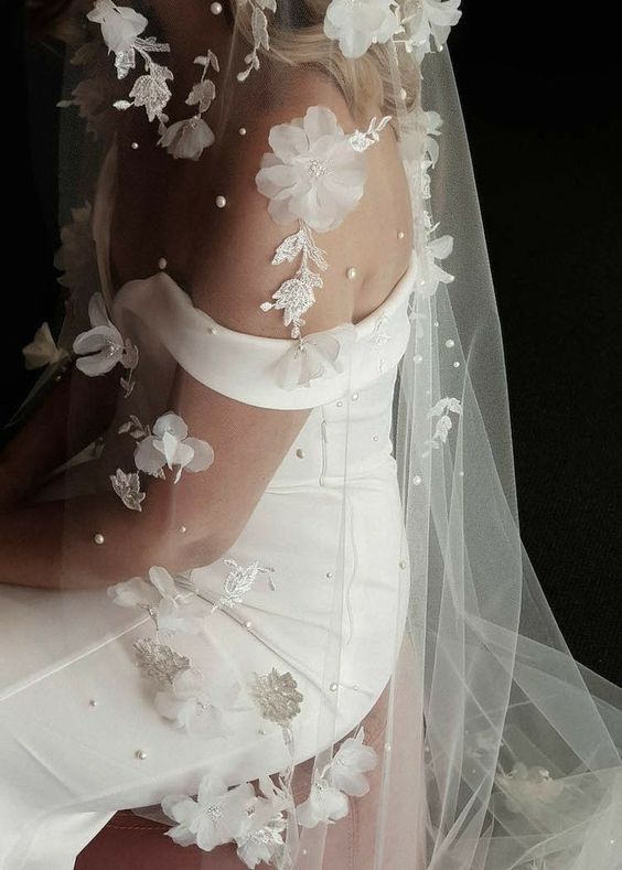 a refined modern wedding dress and a cathedral veil with pearls and white fabric beads are a beautiful idea for a modern refined bride