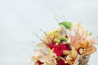 08 a colorful winter wedding bouquet including red roses, orange orchids, poinsettias, berries, leaves and twigs
